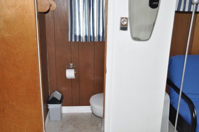 A bathroom with a toilet and a trash can