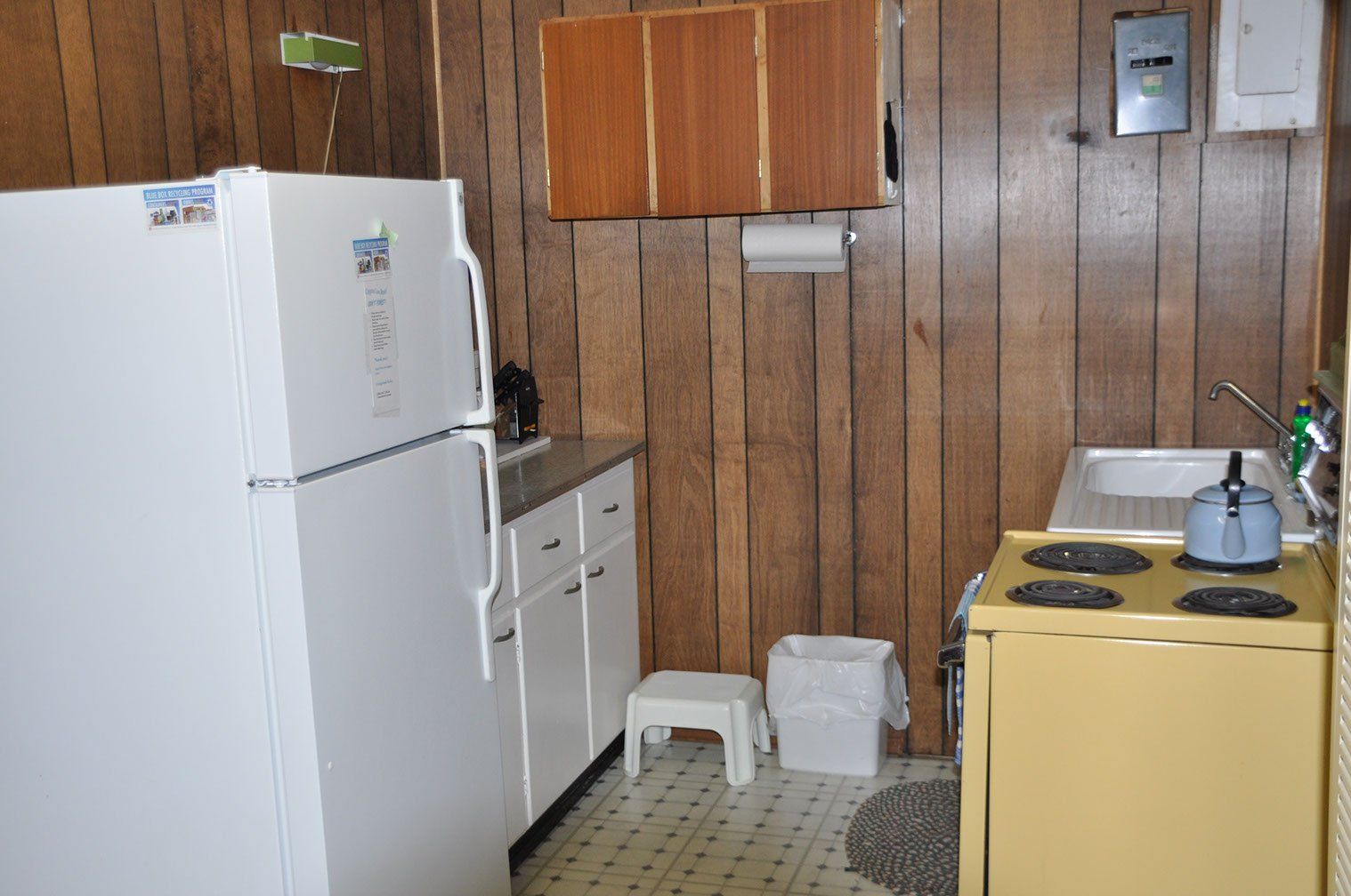 A kitchen with a yellow stove and a white refrigerator