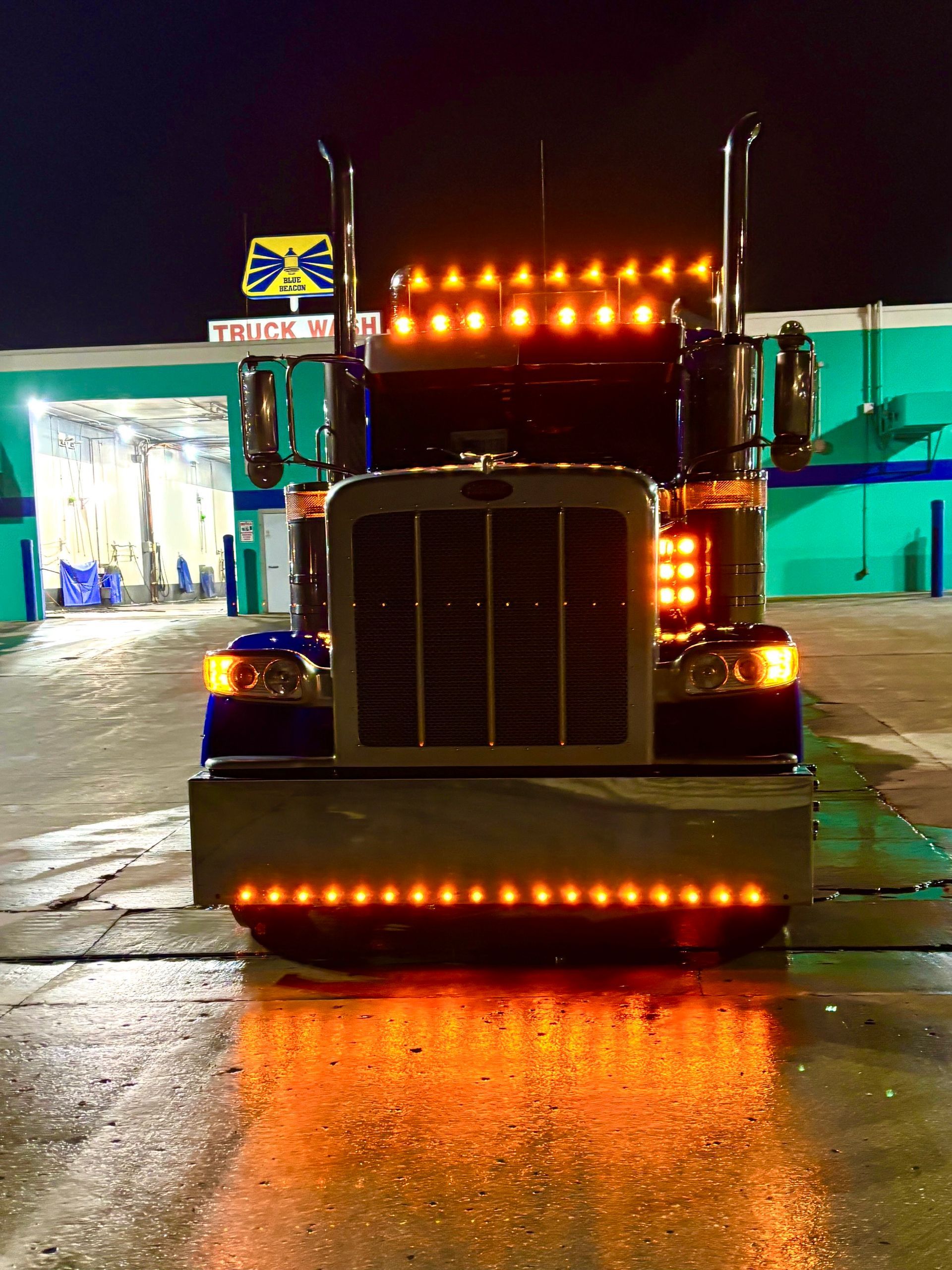 A peterbilt semi truck is parked in front of a building