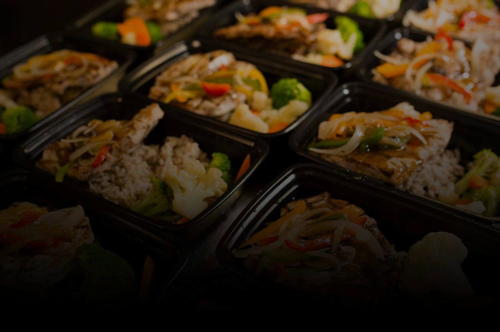 A bunch of plastic containers filled with food on a table.