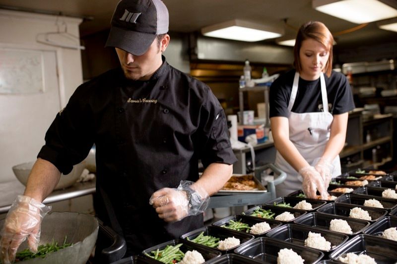 A man and a woman are preparing food in a kitchen