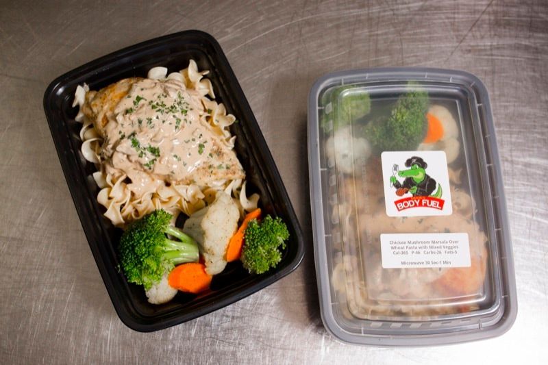 A container of food with broccoli and carrots next to a container of food with meat and vegetables.