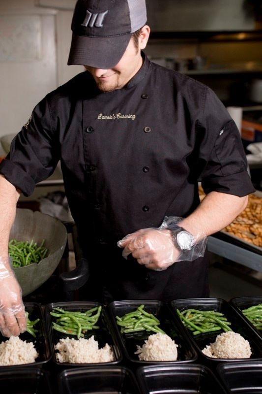 A man in a chef 's uniform is preparing food in a kitchen.