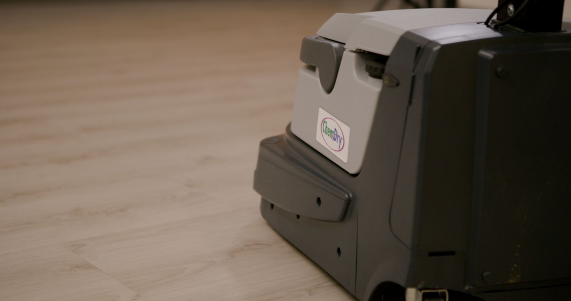 A blue Chem-Dry carpet cleaning machine rests on a white floor.