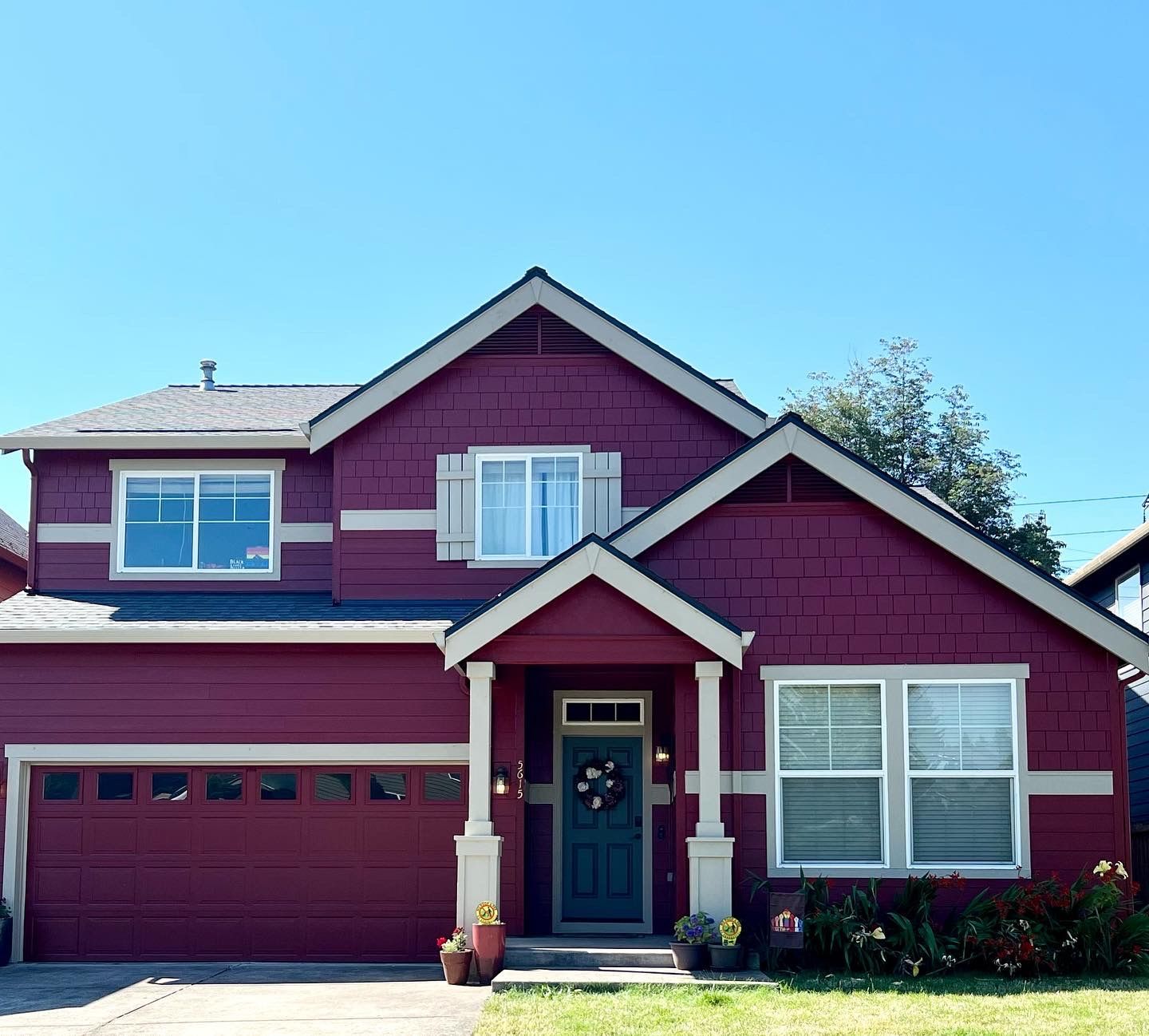 A red house with white trim and a blue door
