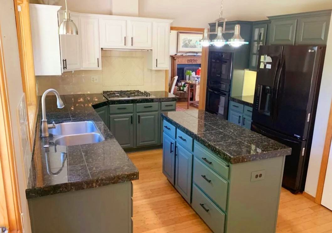 A kitchen with a sink , refrigerator , and stove.
