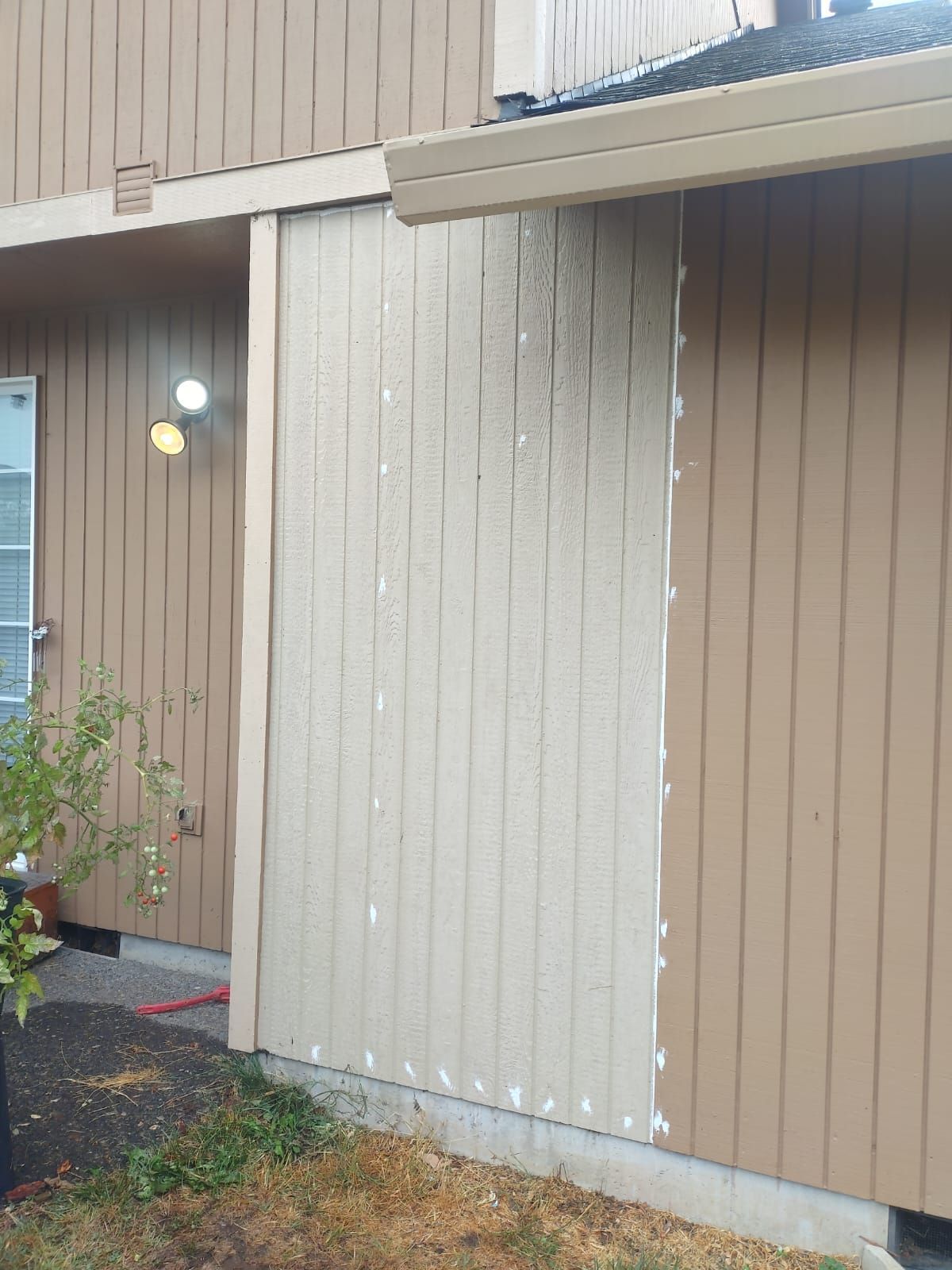 A brown house with a white siding and a window