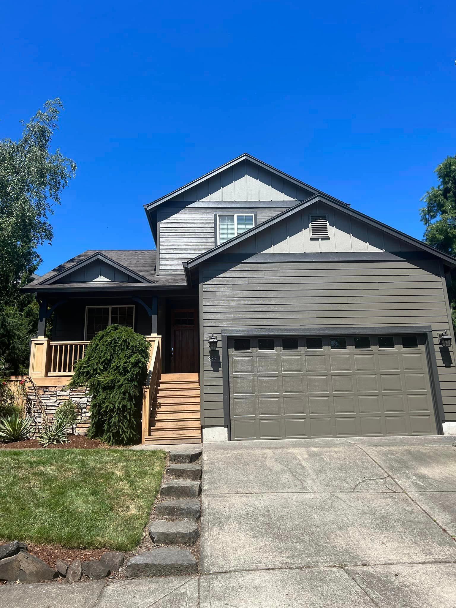 A large house with a garage and stairs in front of it.