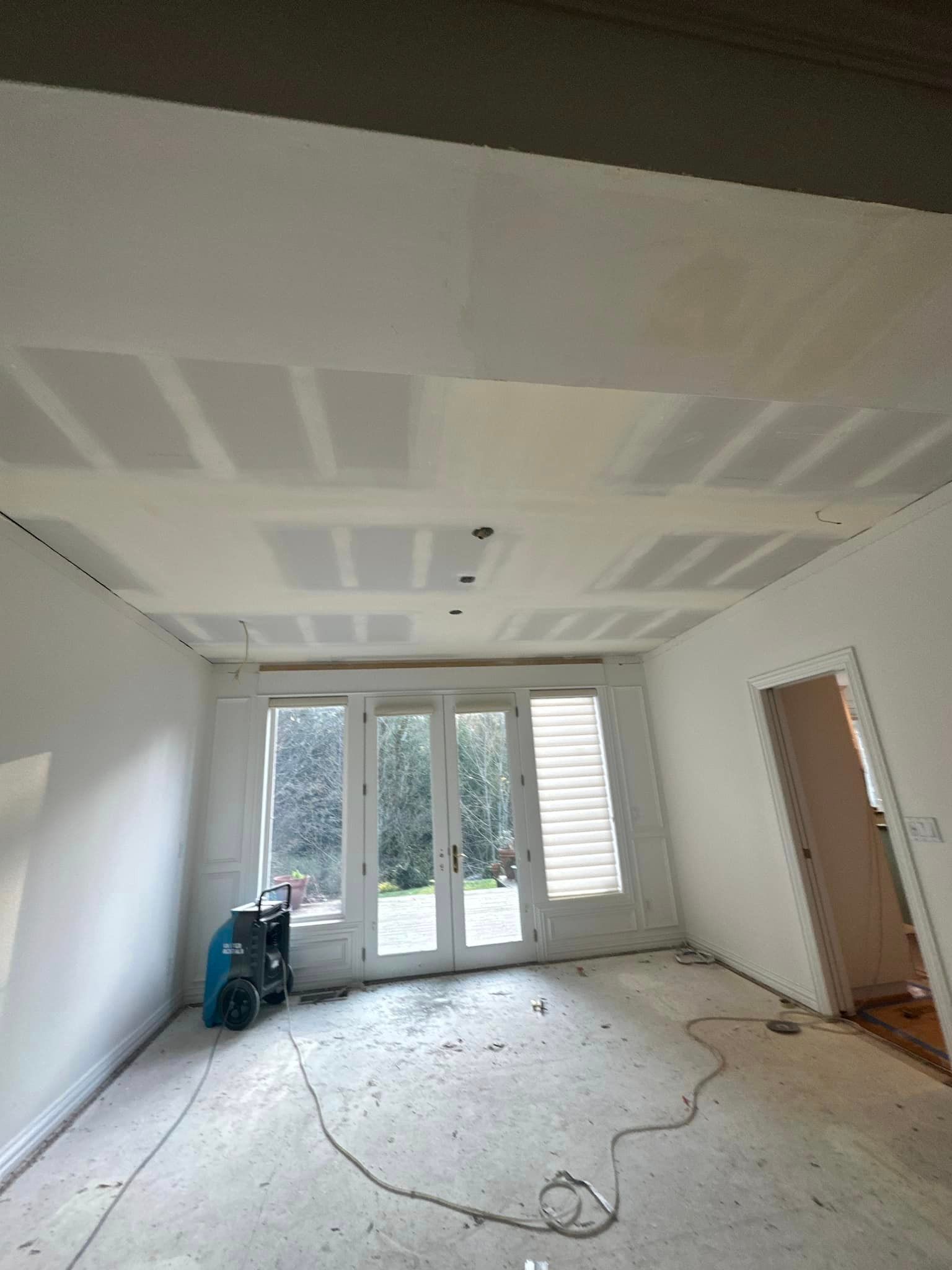 A large room with a lot of windows and drywall on the ceiling.