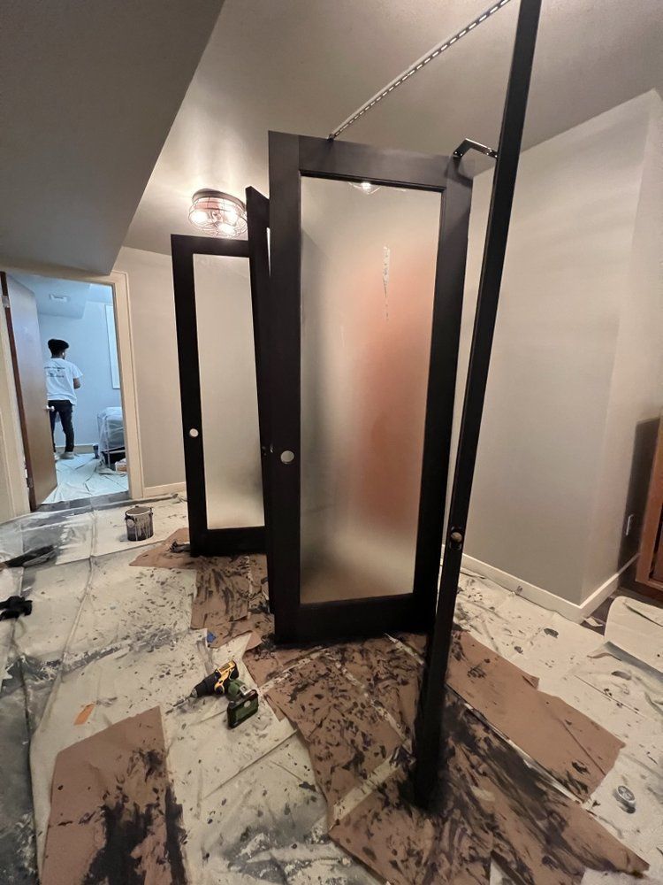 A couple of doors are sitting on the floor in a room.