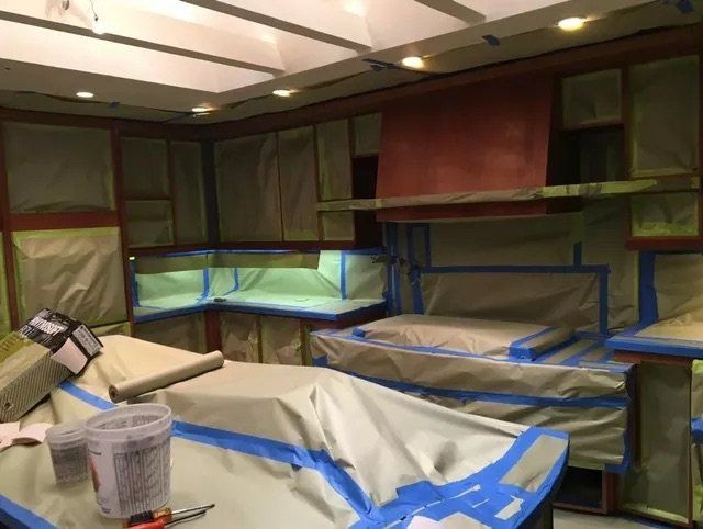 A kitchen that is being painted with blue tape