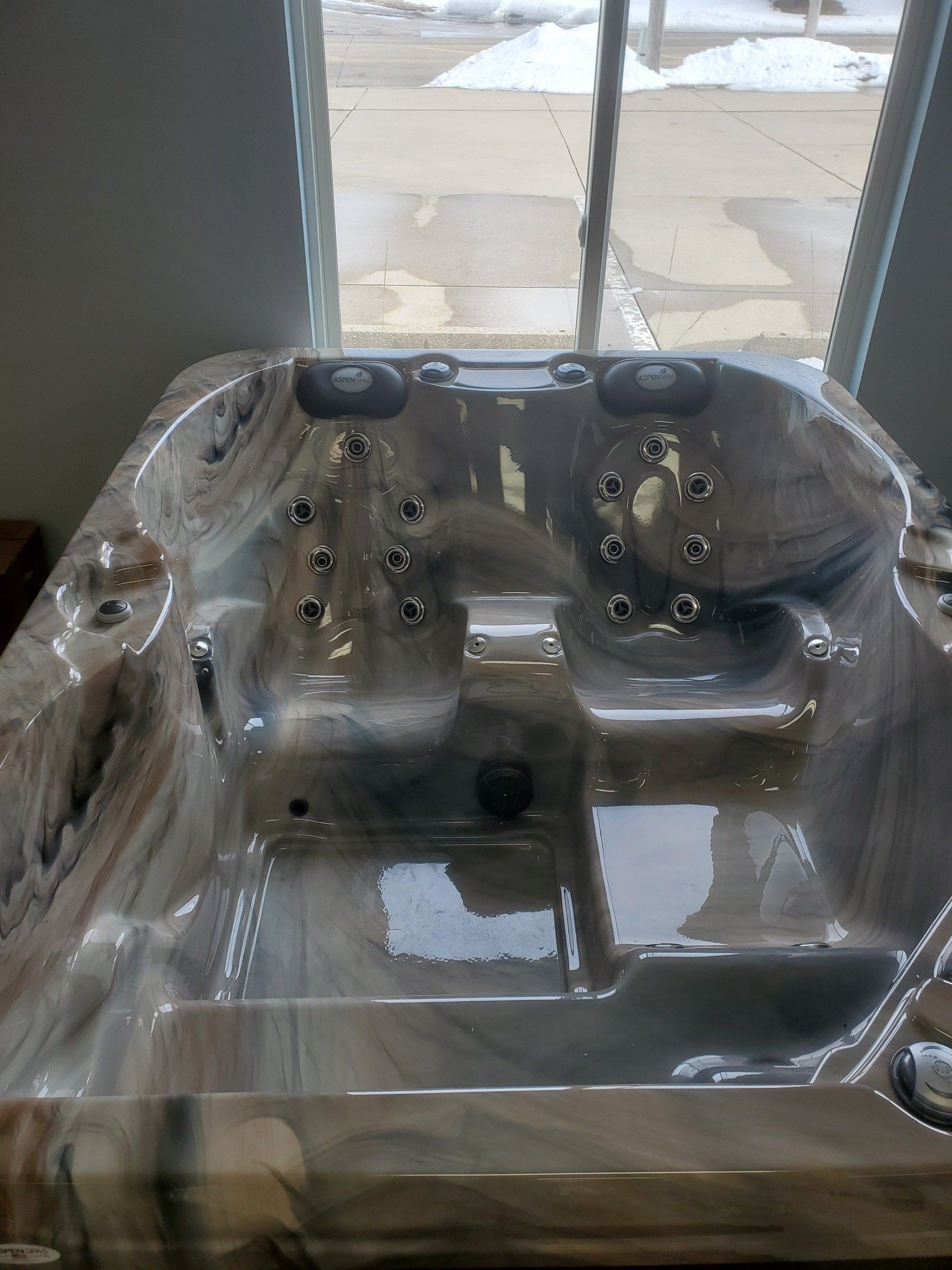 A hot tub is sitting in front of a window in a room.