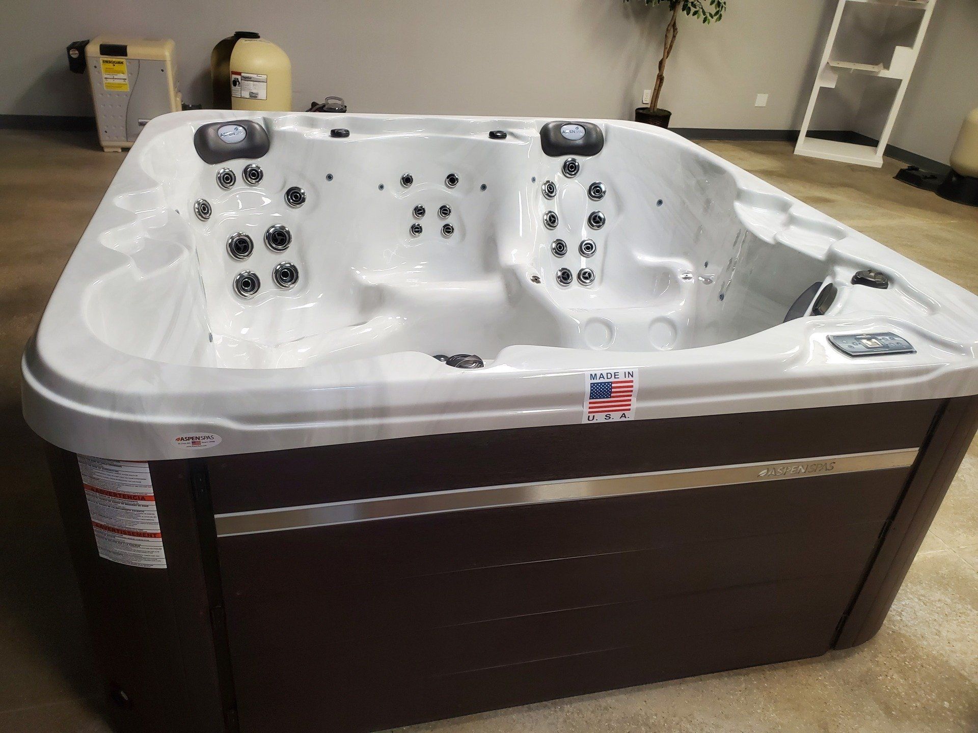 A large white and brown hot tub is sitting in a room.