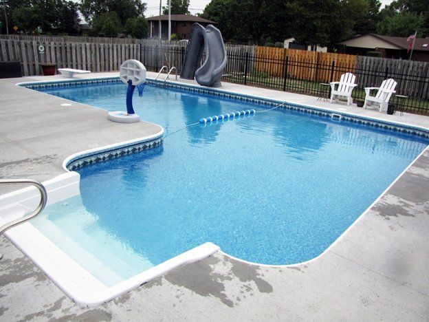 A large swimming pool with a slide in the backyard