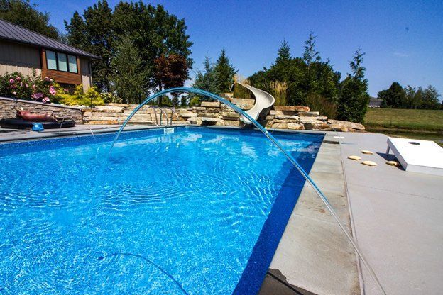 A large swimming pool with a water slide in the background