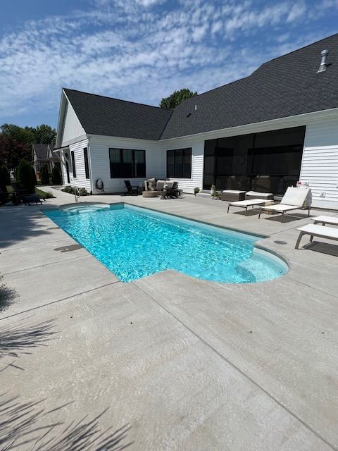 A white house with a large swimming pool in front of it