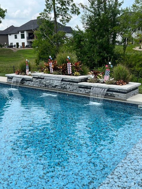 A large swimming pool with a waterfall in the middle of it