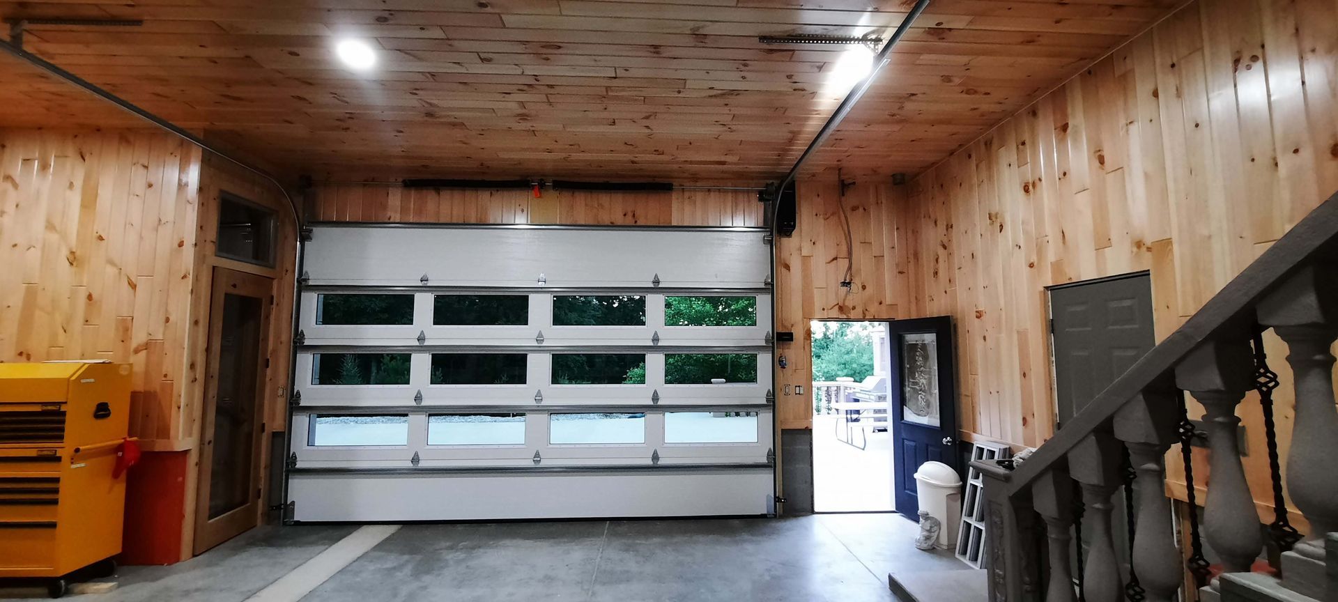 A garage with a large garage door and wooden walls.