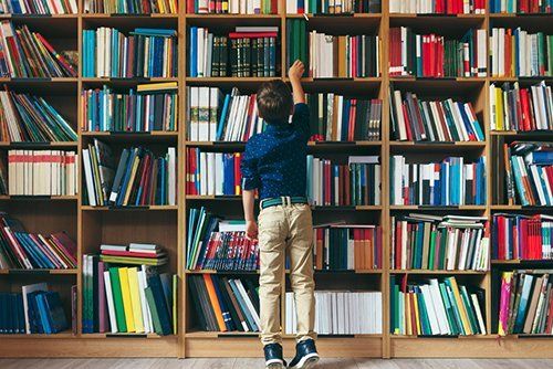 un bambino che cerca un libro in una libreria
