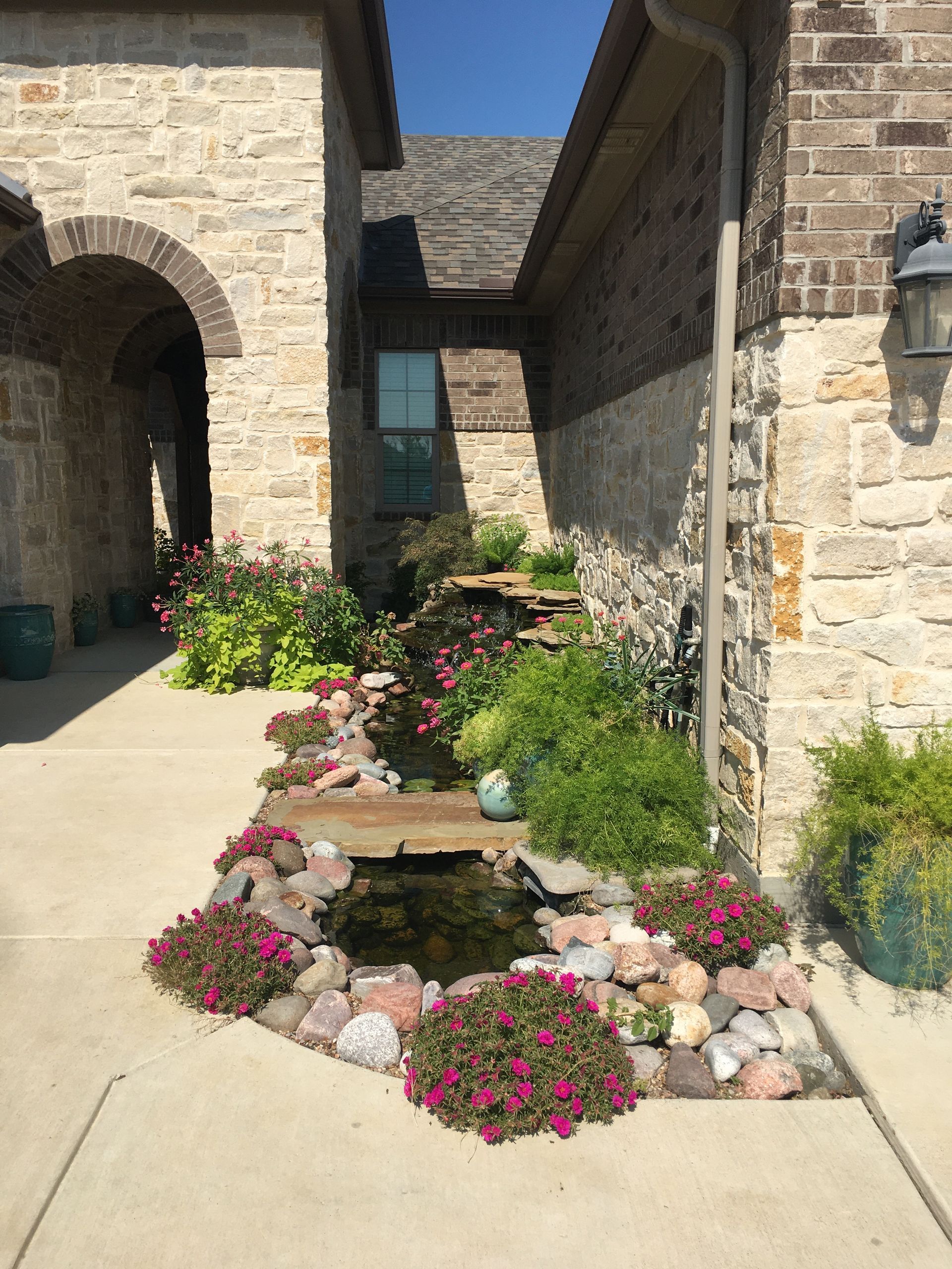 A stone house with a pond in front of it