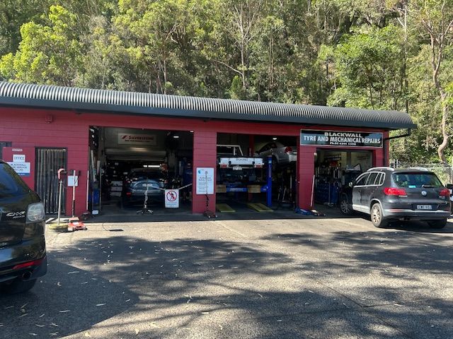 The Underside of a Car is Shown on a Wooden Platform — Blackwall Tyre Service & Mechanical Repairs In Blackwall, NSW