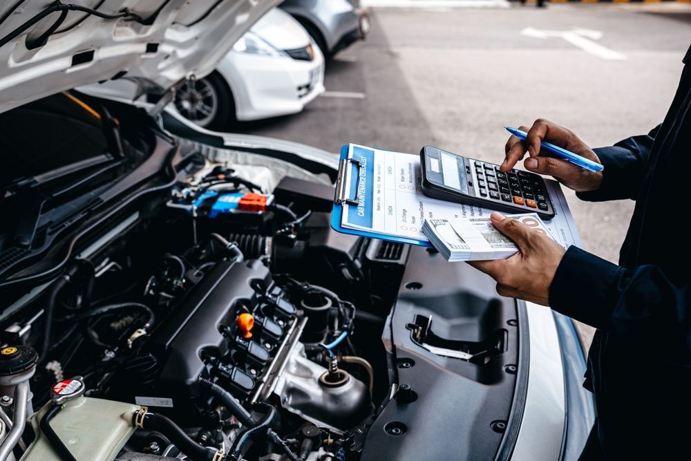 A Man is Working on the Engine of a Car — Blackwall Tyre Service & Mechanical Repairs In Blackwall, NSW