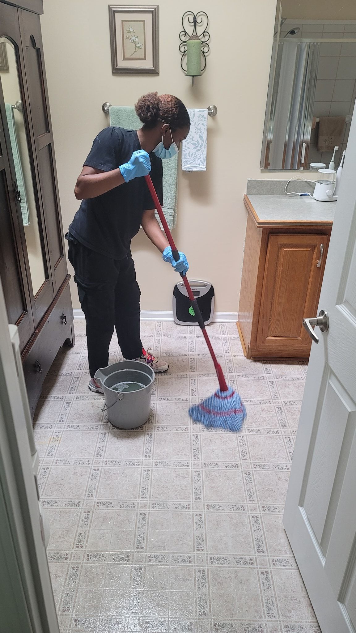 DAG cleaners is cleaning the floor of a bathroom with a mop.