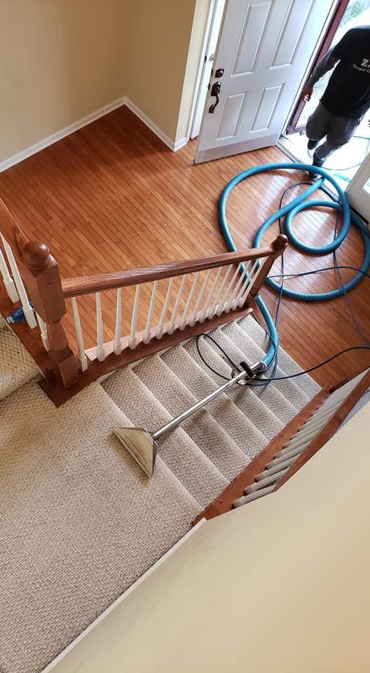 Cleaning a carpeted staircase with a vacuum cleaner.