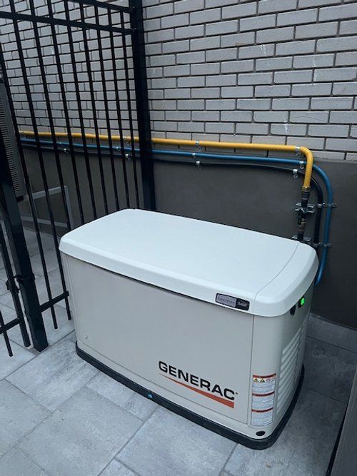 Un générateur est placé sur le côté d'un bâtiment à côté d'une clôture.