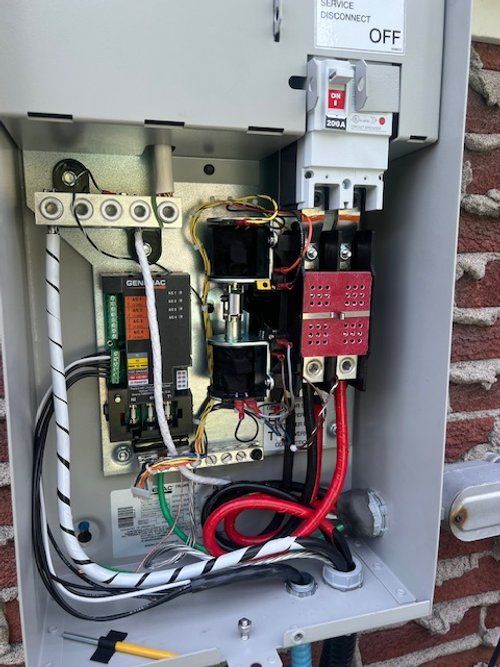 L'intérieur d'une boîte électrique avec beaucoup de fils qui en sortent.