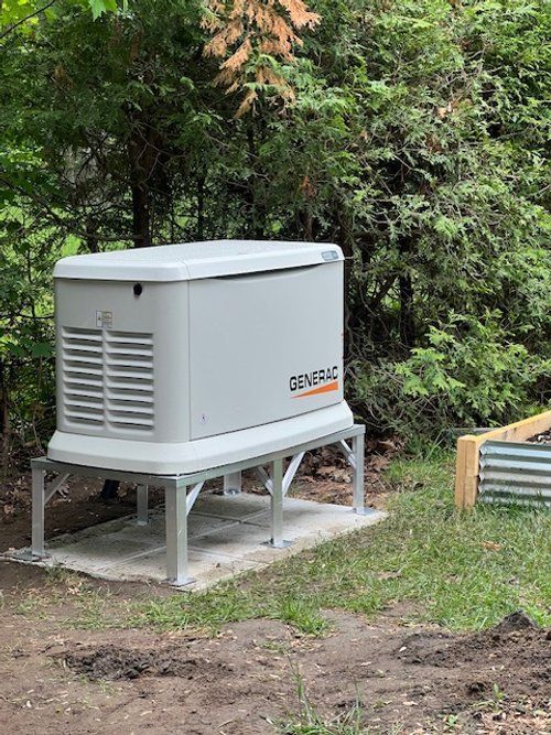 Un générateur est posé sur une plate-forme en béton au milieu d'un champ.