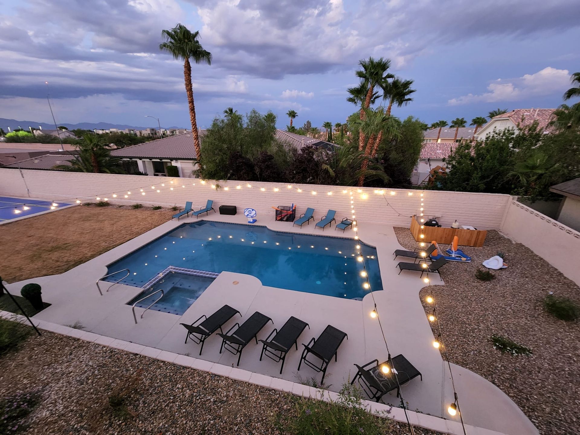 Night time pool with stringed lights pool chairs