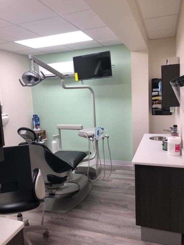 chair with sink and lamp over chair and tv on green wall