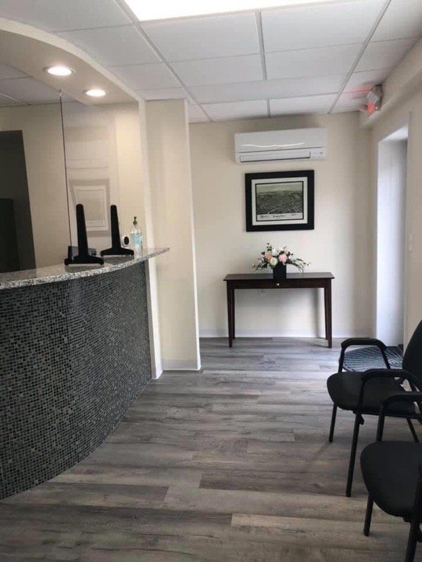 office with desk and chair and table with flower and painting