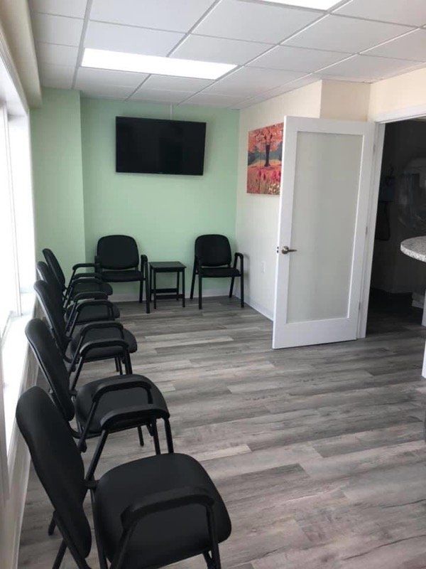 office with chairs and tv and painting on green wall