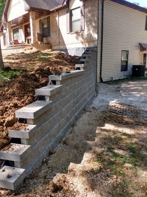 A brick wall is being built in front of a house
