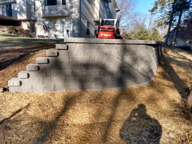 A brick wall is being built in front of a house.