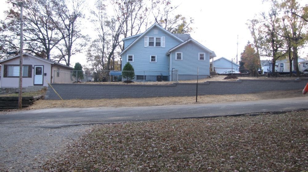 A house with a lot of leaves on the ground in front of it