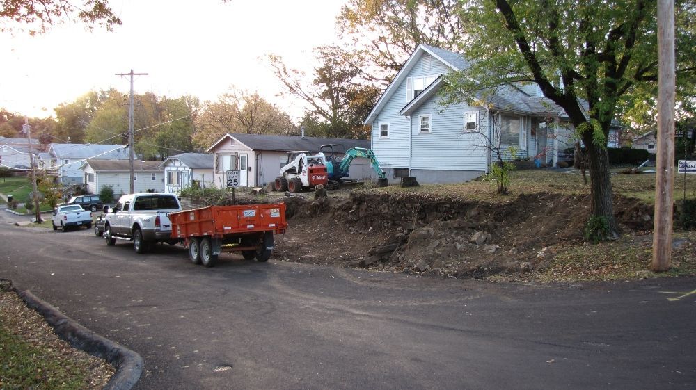 A white truck with a red trailer is parked on the side of the road