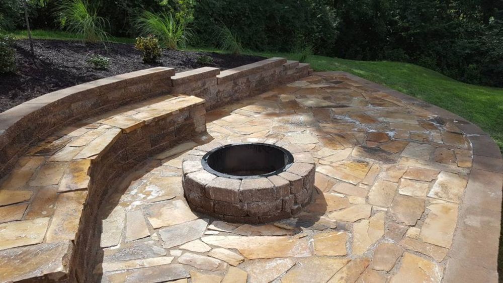 A fire pit is sitting on top of a stone patio.