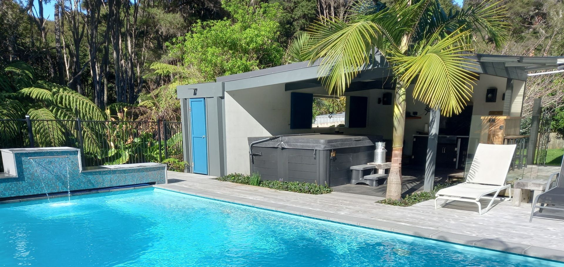 A large swimming pool with a hot tub in the background