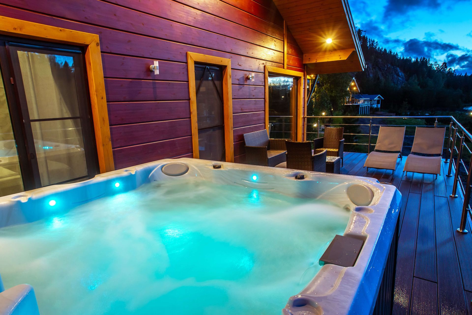 A hot tub is sitting on the deck of a house.