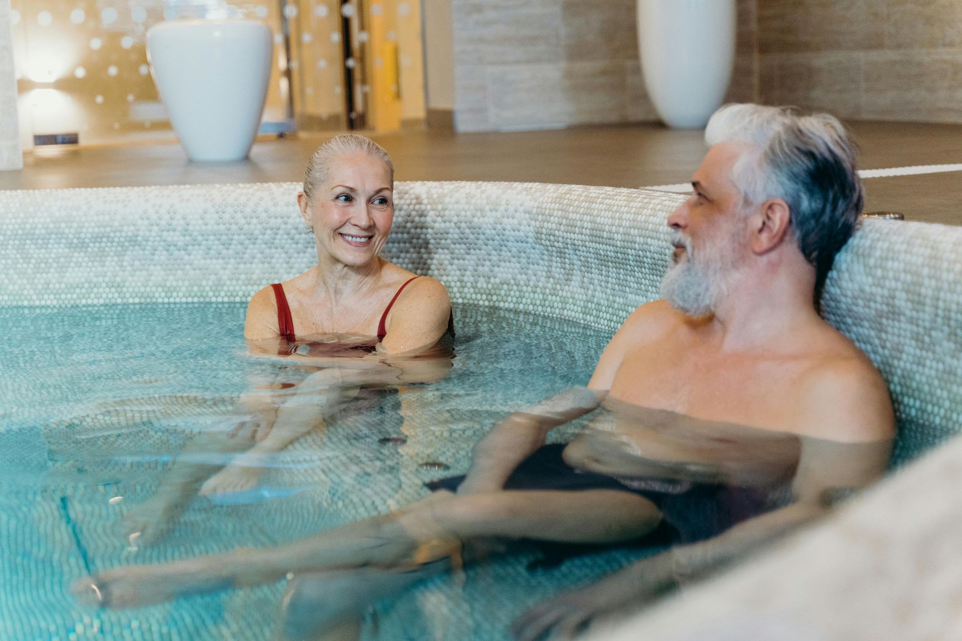 A man and a woman are sitting in a hot tub.