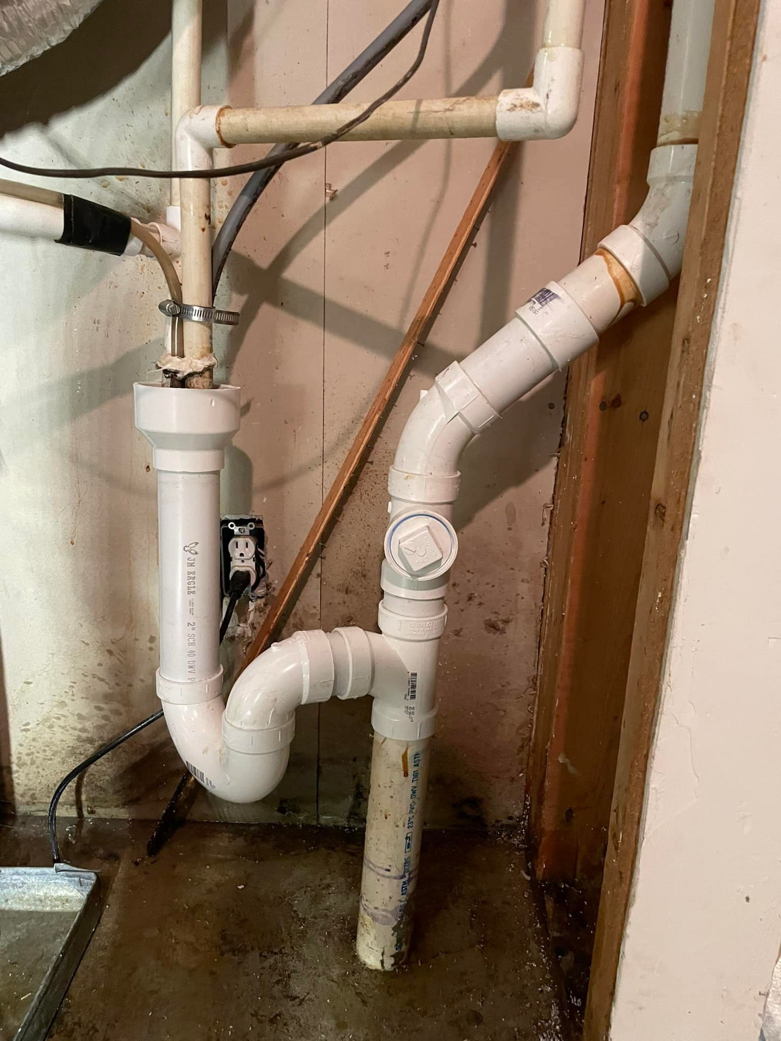 A close up of a drain pipe in a basement