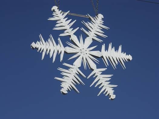A snowflake with six symmetrical arms and intricate patterns on a blue background.