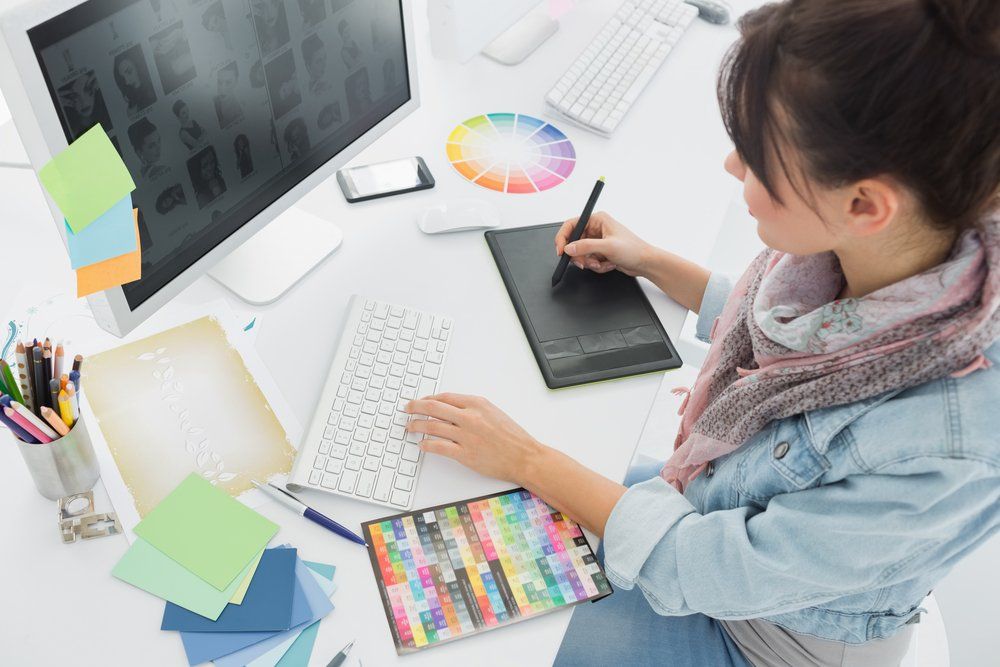 A woman is sitting at a desk working on a computer.