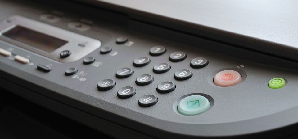 A close up of a remote control on a printer.