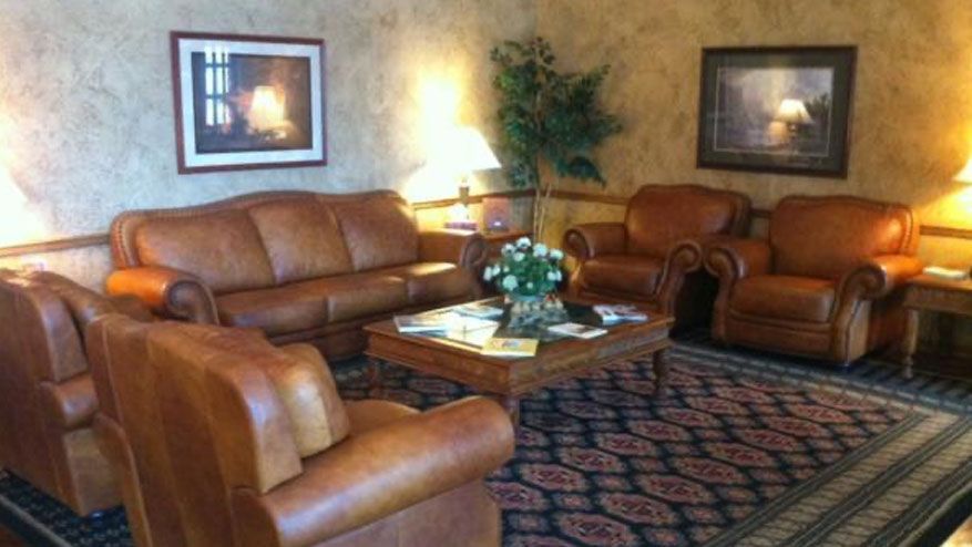 a living room with brown leather furniture and a rug