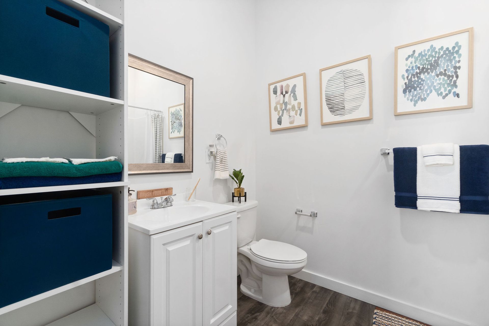 A bathroom with a toilet , sink and mirror.