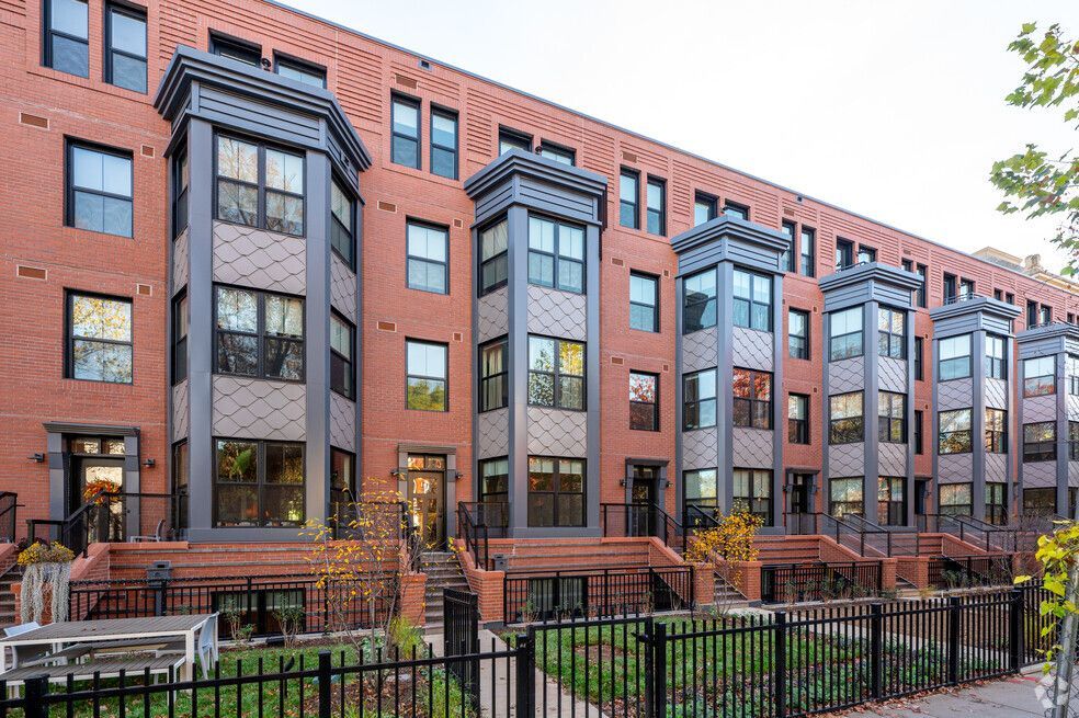 A large brick apartment building with a fence in front of it.